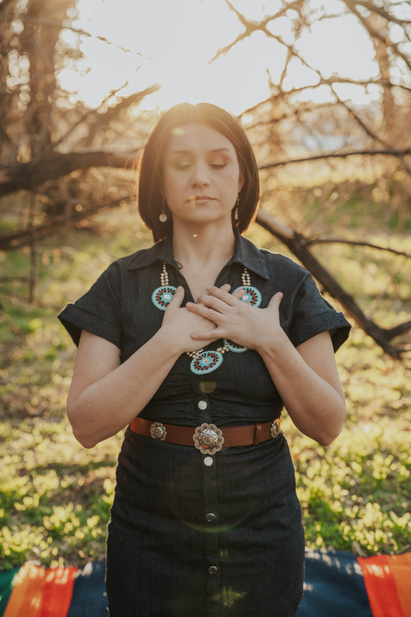 Native therapist resting a hand on her heart during Heart-Centered Hypnotherapy