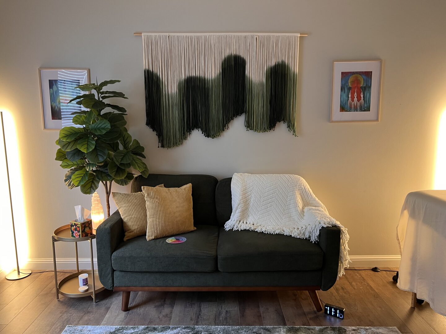 Therapy office with a green couch and plant at NATIVation Counseling
